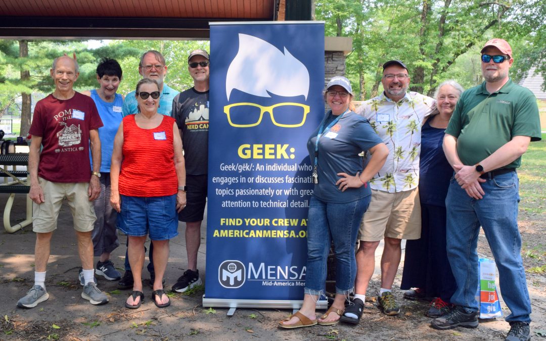 Group photo of people at a picnic with Geek sign